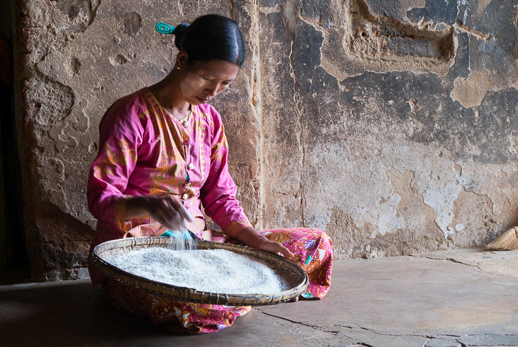 Burmese woman with a basket full of rice