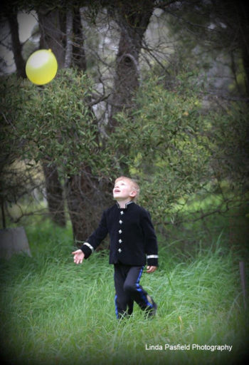 camera shy young man with a ball plays while having his portrait taken