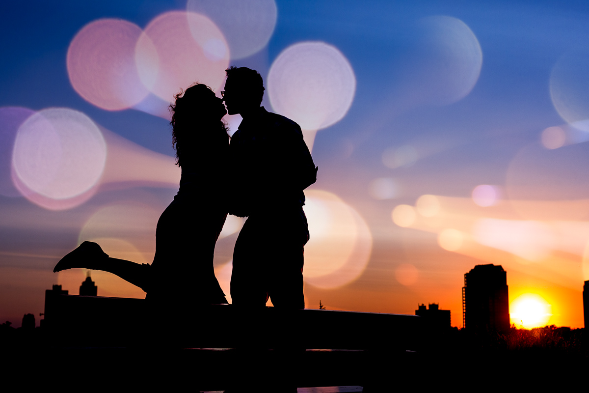 couple kissing at sunset with bokeh applied for a creative touch