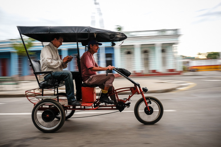 continuous drive mode while panning captured this sharp photo of the series of bike taxi photos above