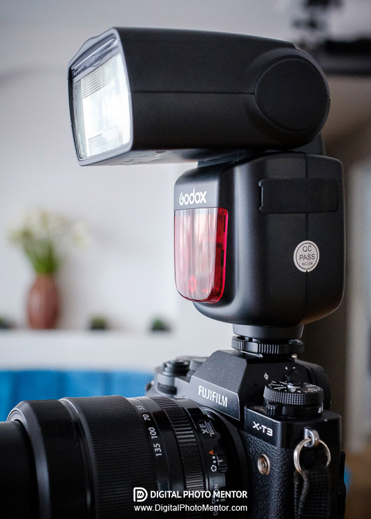 Godox flash shown attached to camera hot shoe and ready to fire