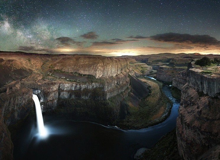 Long exposure photograph of a waterfall with the night sky as a backdrop