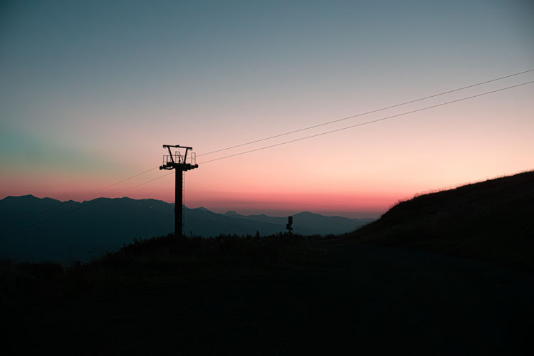 Silhouette of ski lift at sunset