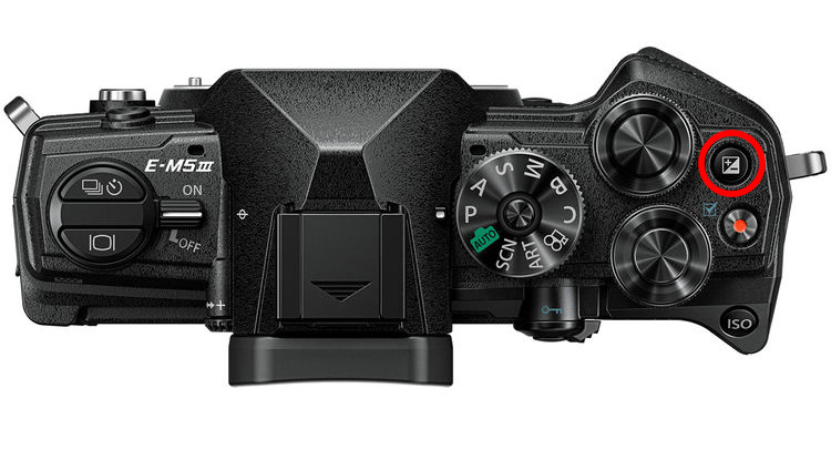 Where to find exposure compensation on an Olympus camera