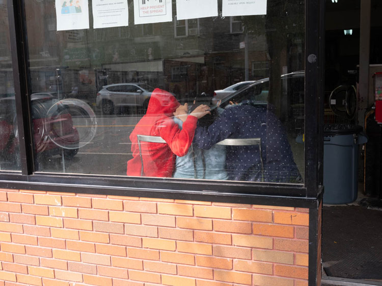 group of people inside laundromat through window before editing 
