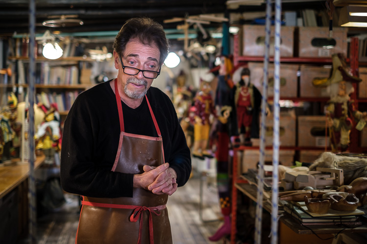 Portrait photo of puppet maker Roberto Comin in his shop in Venice Italy