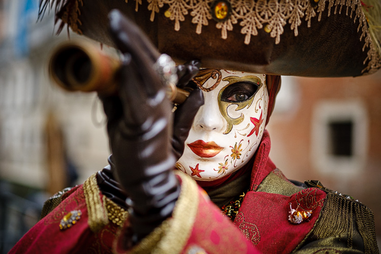 masked character at carnival looking through periscope