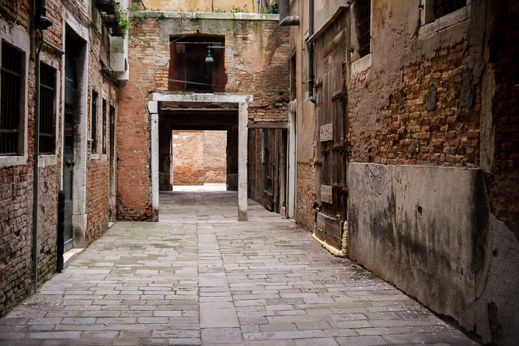 An empty courtyard with bricks and archway makes for the perfect shooting location