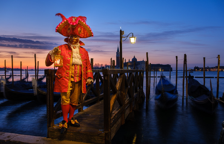 brilliant red costumed character at sunrise in St Marks square