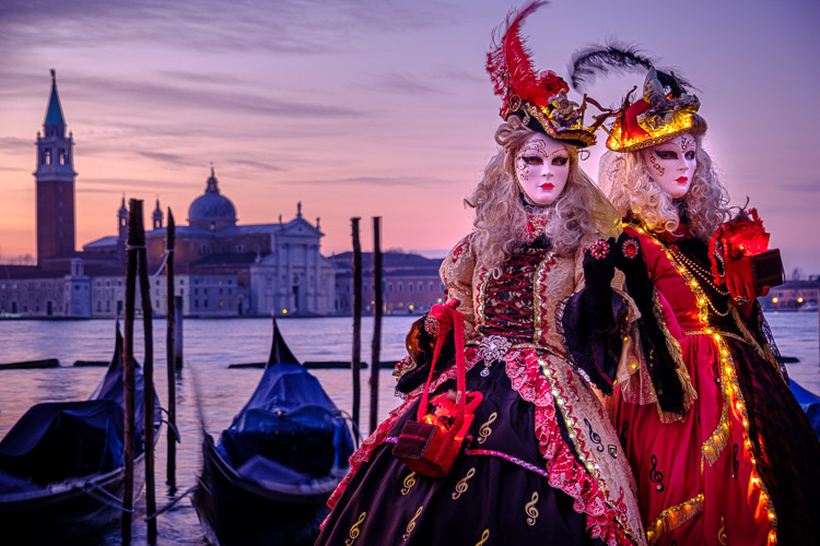 two models pose in St Marks square at sunrise with gondolas