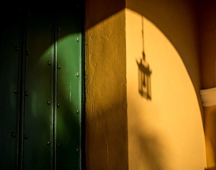 The shadow of a porch light shown prominently on the side of the building