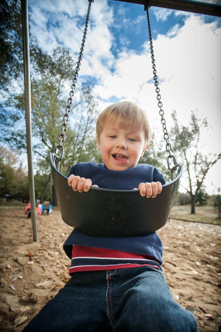 a fun portrait example of a child on a swing taken with a wide angle lens