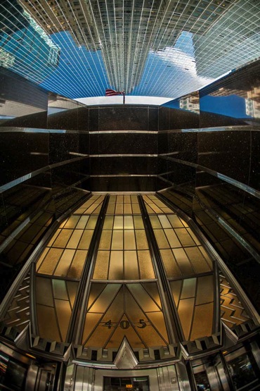 wide angle lenses make lines in the photo converge to a single point as seen in this upward pointing photo between two buildings