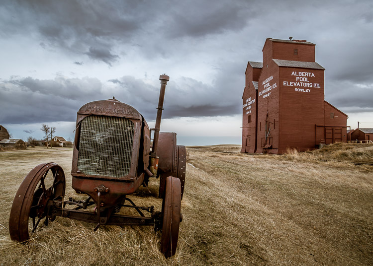 a wide angle lens adds depth and makes the old tractor look good with the grain elevators in the background